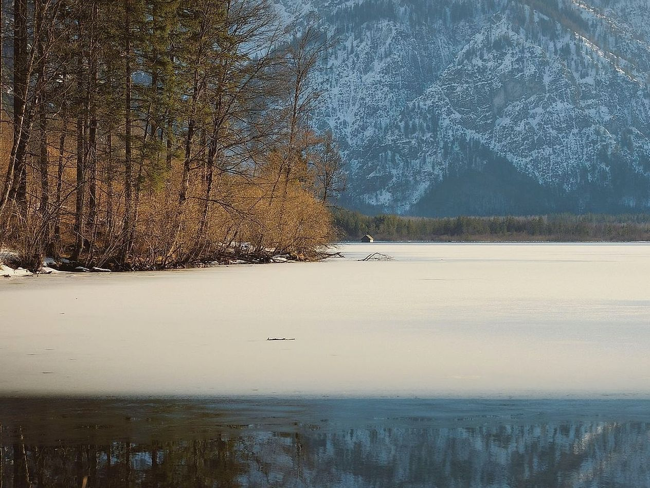Un lago bajo el hielo al amanecer, antes de que la luz llegue completamente